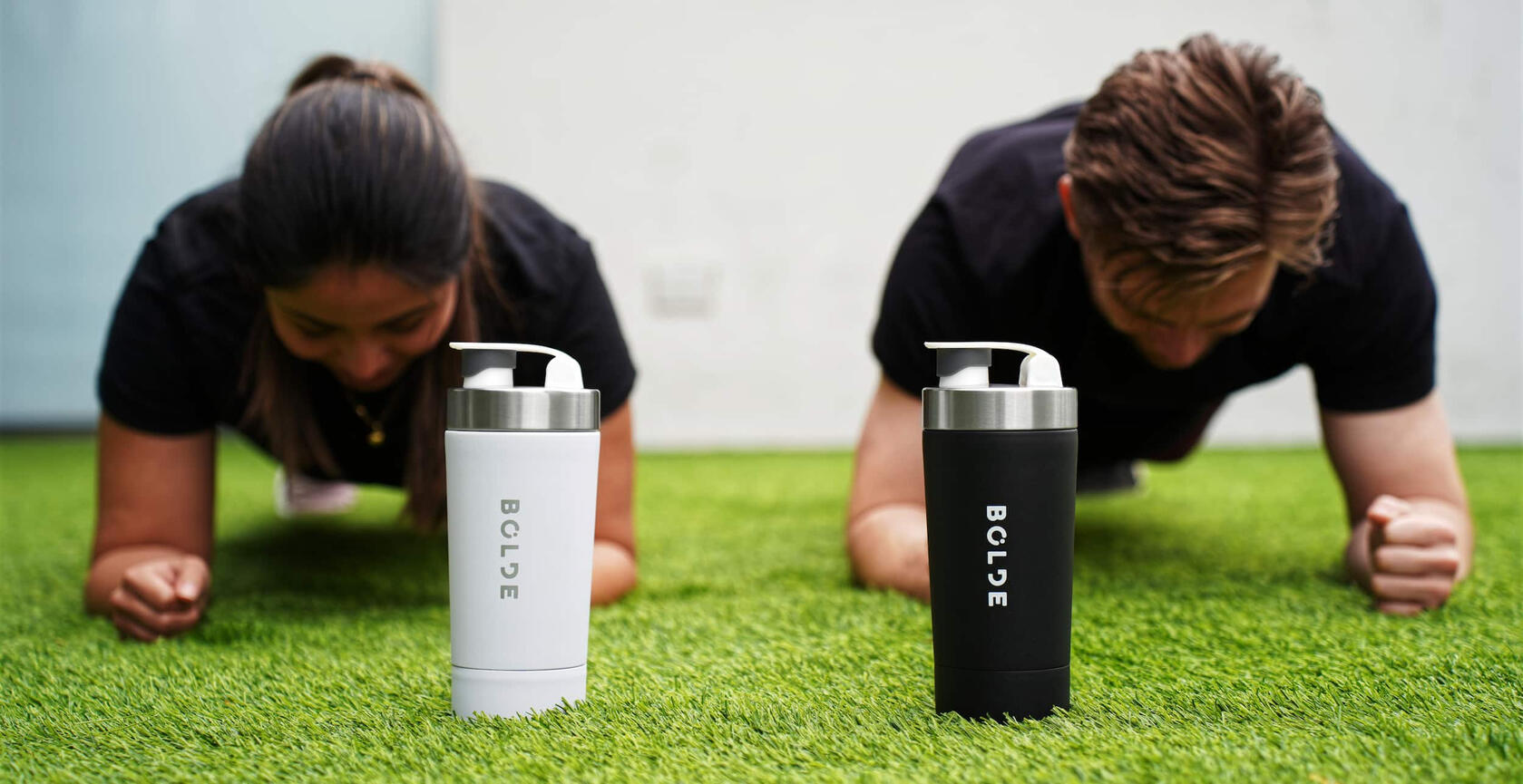 man and woman outdoors planking with BOLDE Bottle